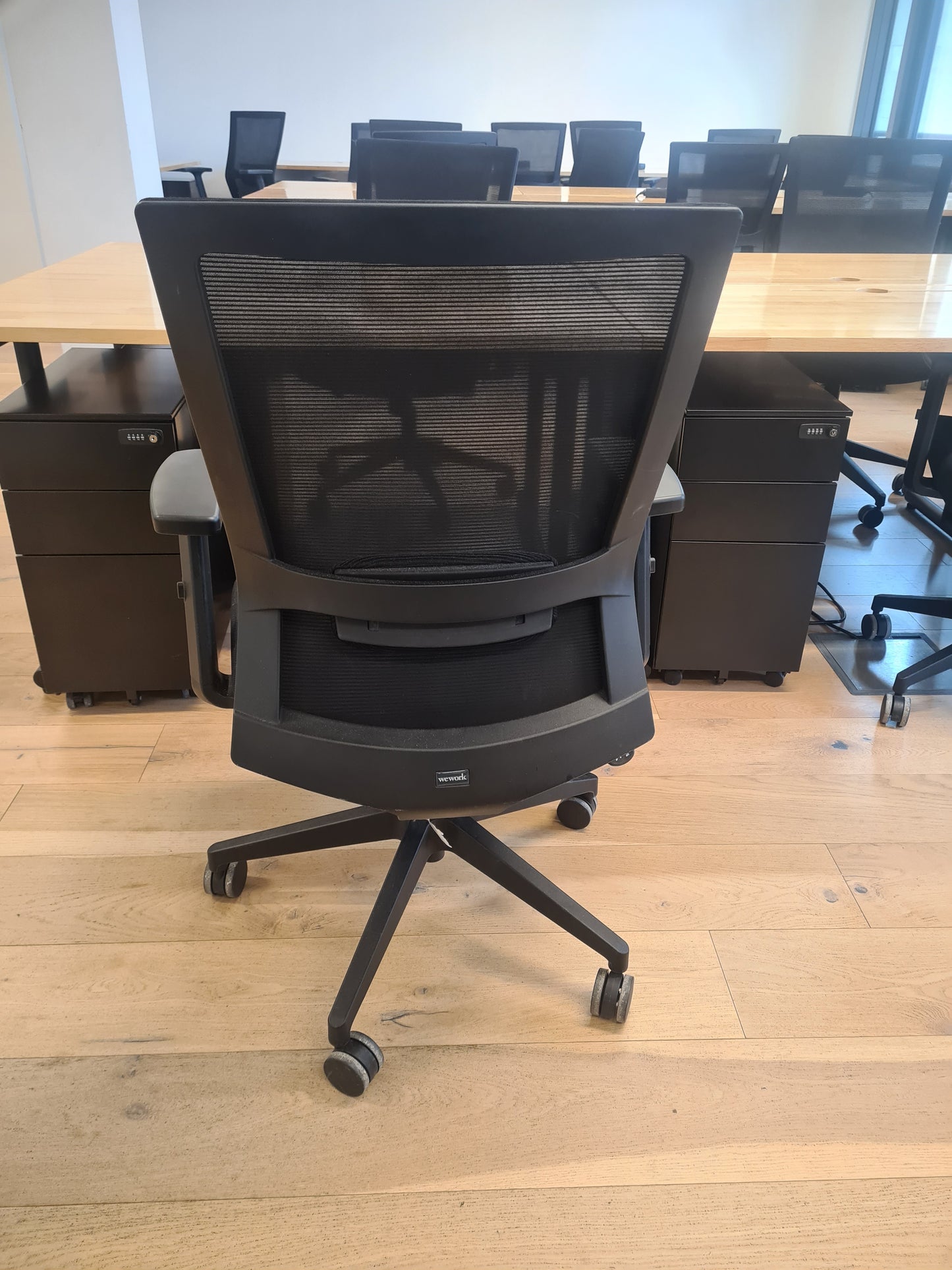 Chaise de bureau reconditionnée avec dossier en maille dans un espace de travail partagé.