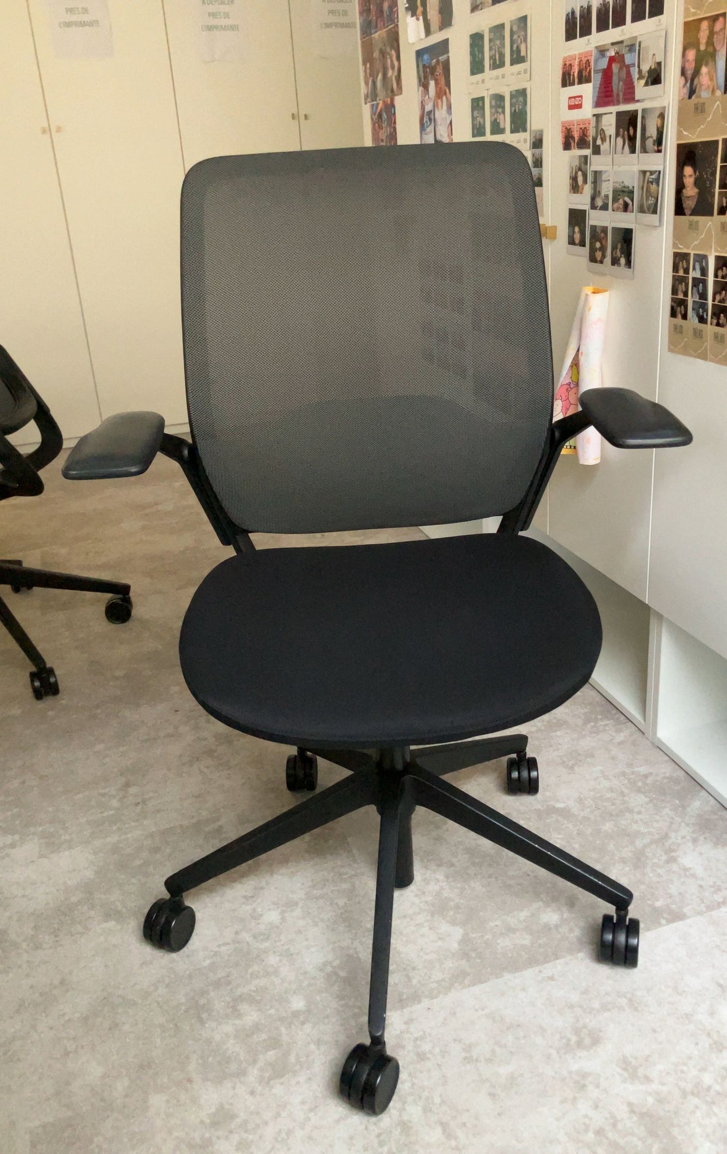 Fauteuil de bureau reconditionné noir avec dossier en maille respirante.