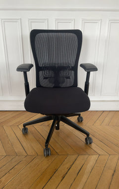 Chaise de bureau reconditionnée avec dossier en maille noire et assise rembourrée.