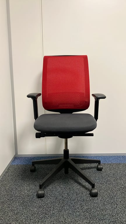 Fauteuil de bureau avec dossier en résille rouge et assise en tissu noir sur piètement en étoile - face
