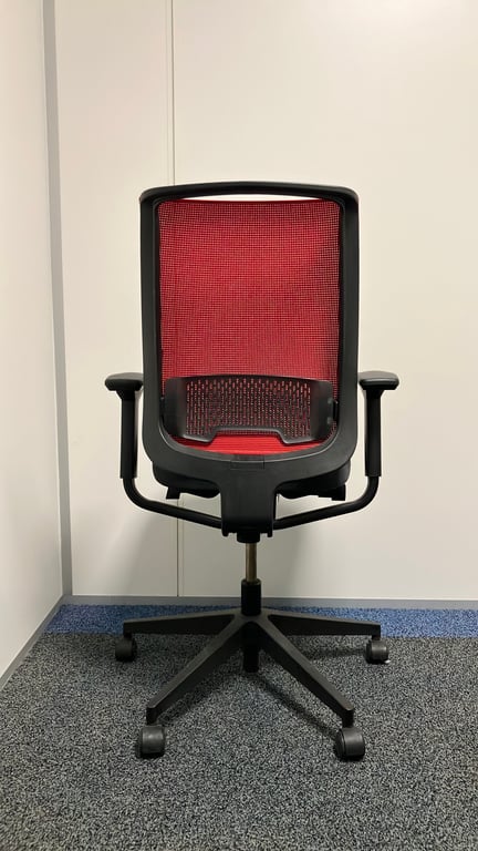 Fauteuil de bureau avec dossier en résille rouge et assise en tissu noir sur piètement en étoile - ambiance