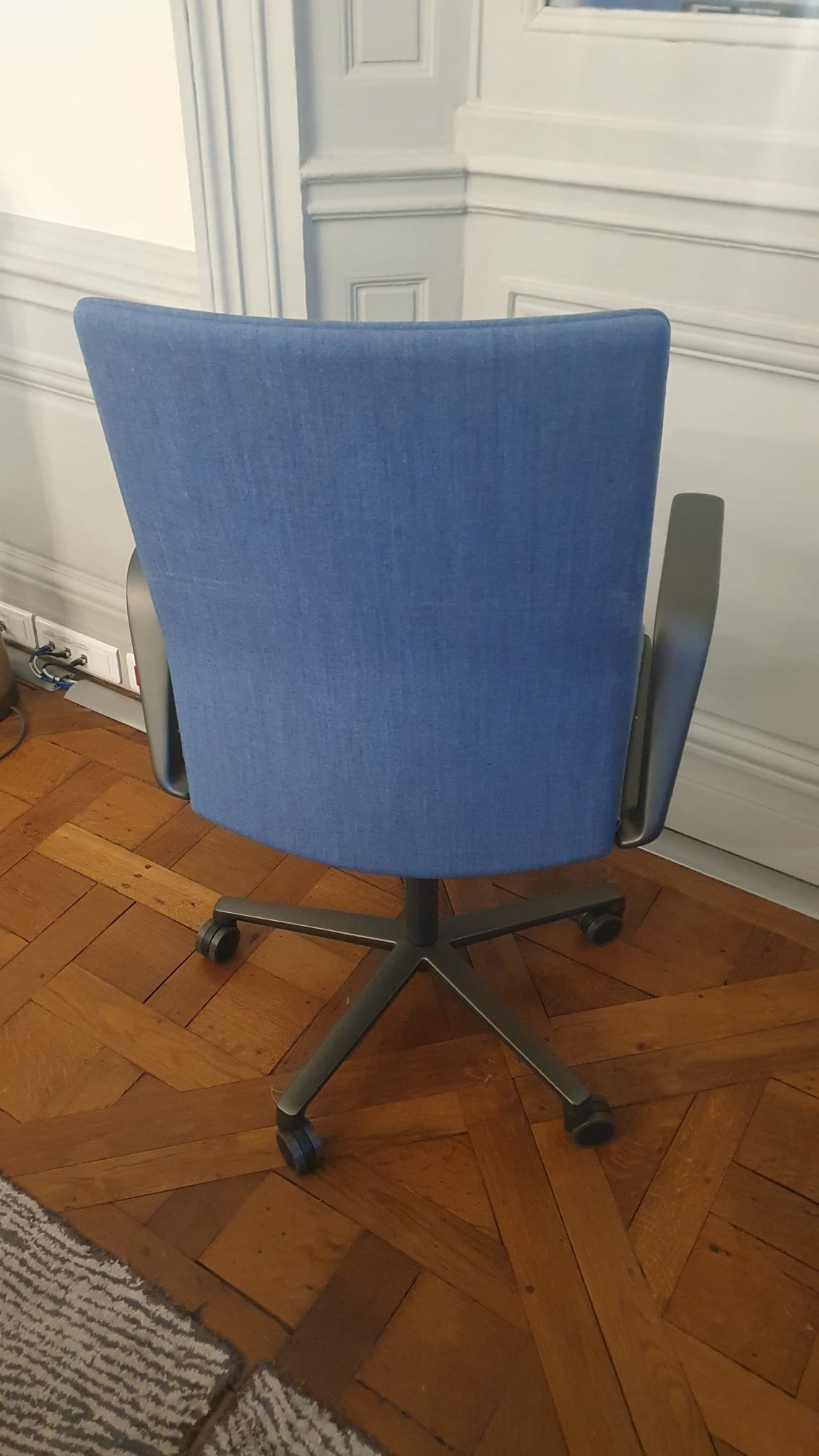 Chaise de bureau reconditionnée avec dossier rembourré bleu et roulettes.