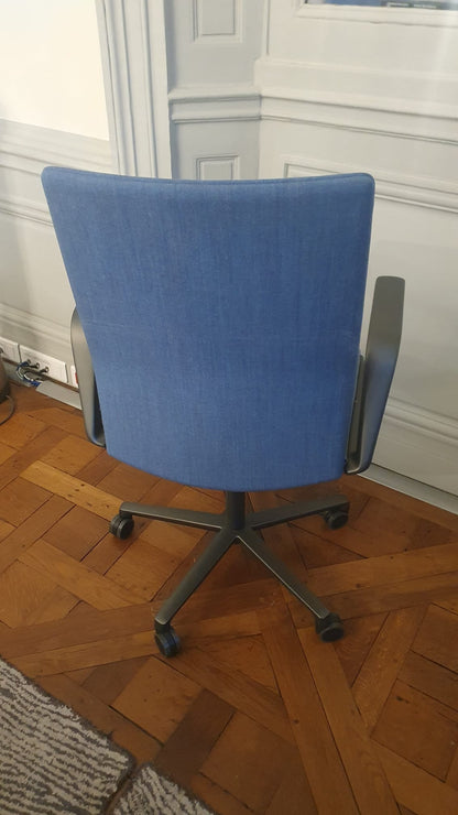 Chaise de bureau reconditionnée avec dossier rembourré bleu et roulettes.